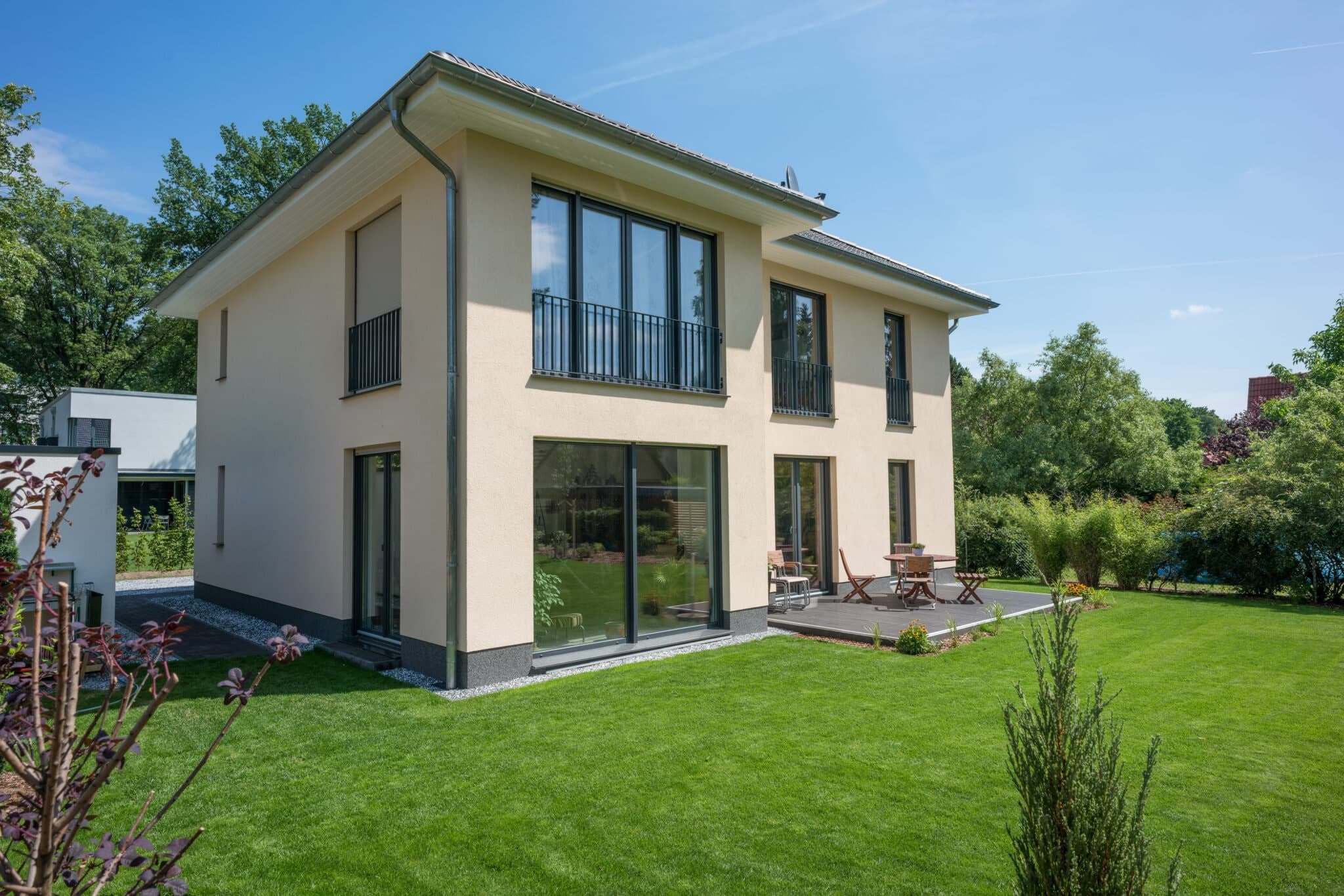 Einfamilienhaus mit Walmdach in Glienicke/Nordbahn – Gartenseite mit Terrasse (HBG Hochbau Berlin)